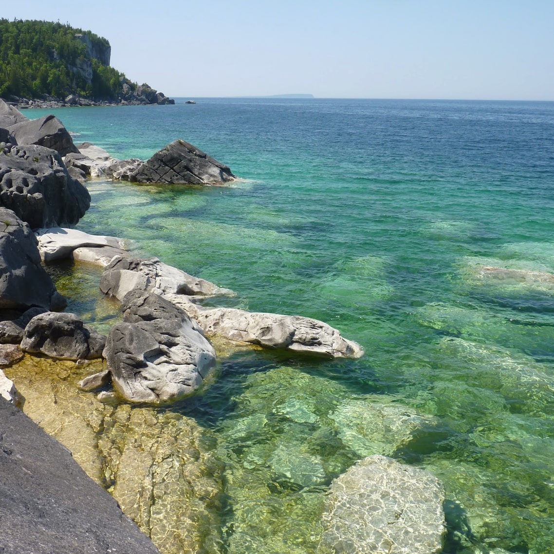 Clear turquoise water by rocky shore