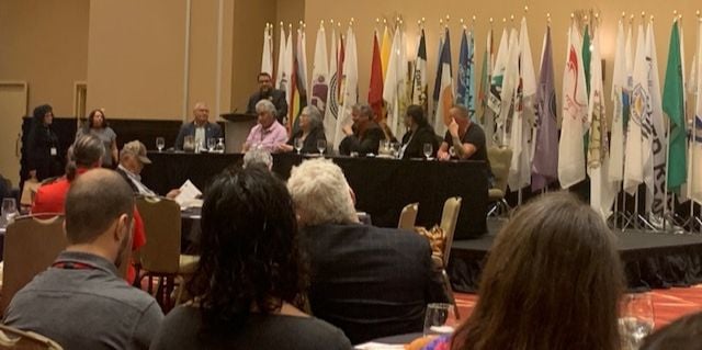 Panel discussion with multiple flags displayed.