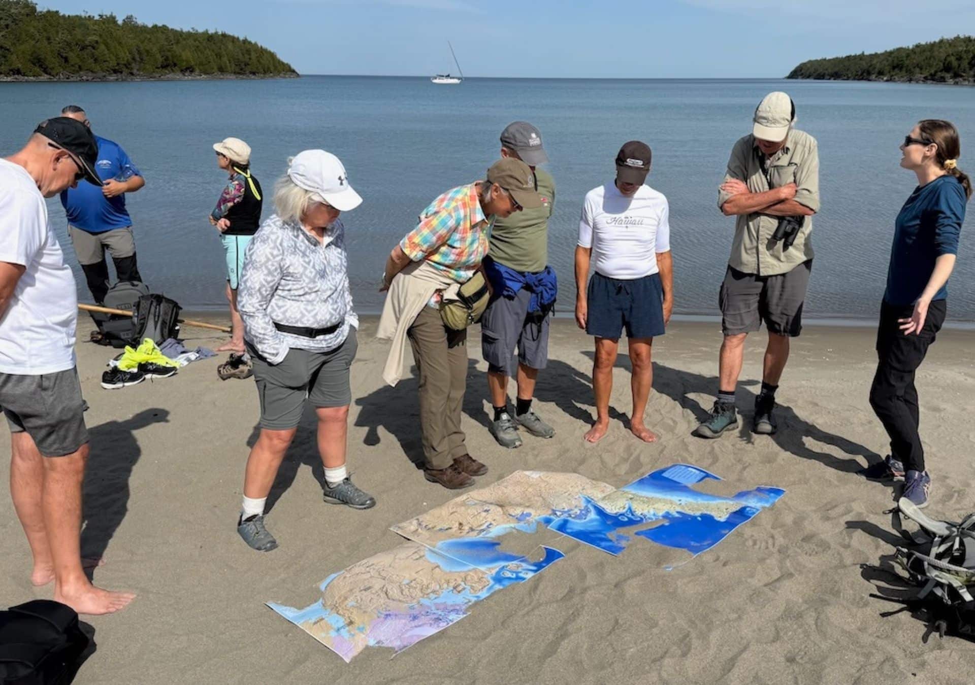 Group examining maps on beach