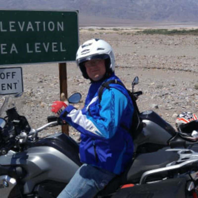 Person on motorcycle near sign