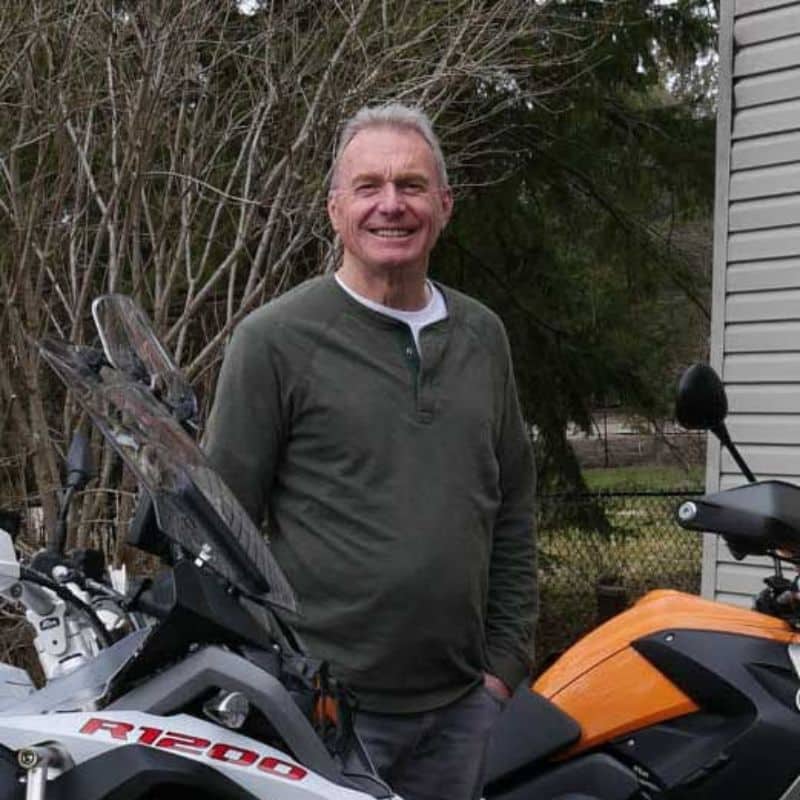 Person near motorcycles in outdoor setting
